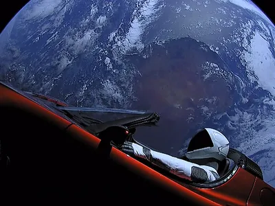 The Tesla Roadster and the mannequin &quot;Starman&quot; on the SpaceX Falcon Heavy upper stage, with Earth in background.