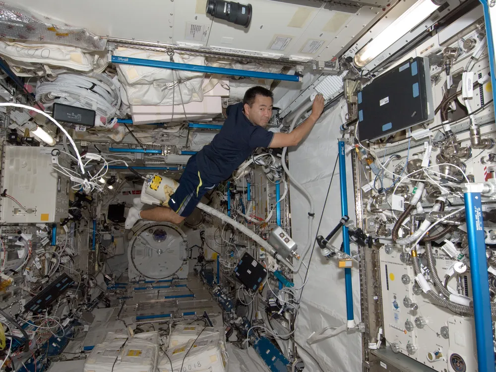 An astronaut using a vacuum cleaner on the ISS
