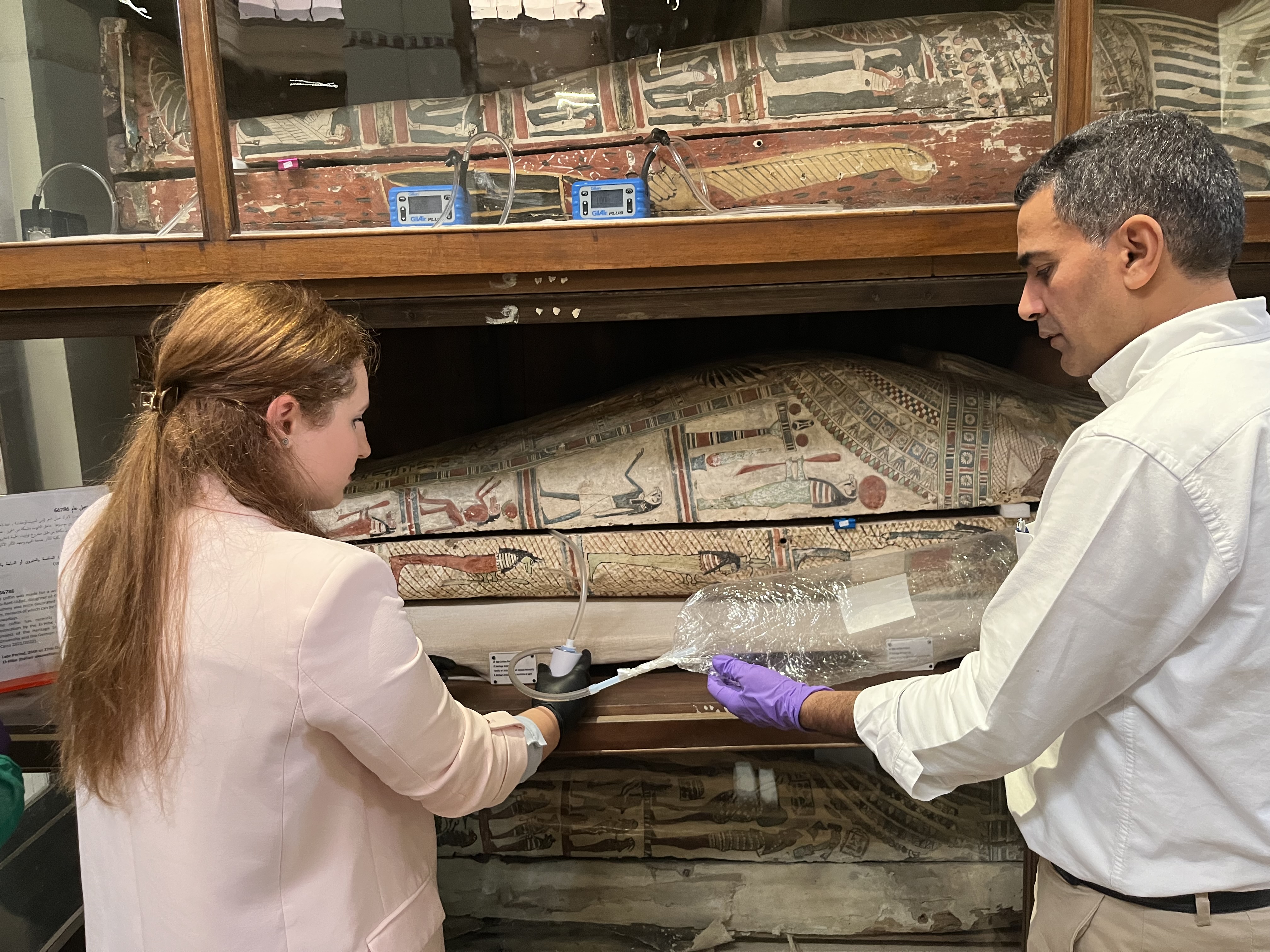 Paolin (left) and Abdelrazek Elnaggar (right) take a sample of the smell of an ancient sarcophagus.