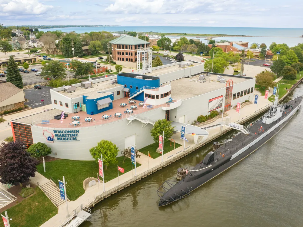 Submarine on river in front of large museum building