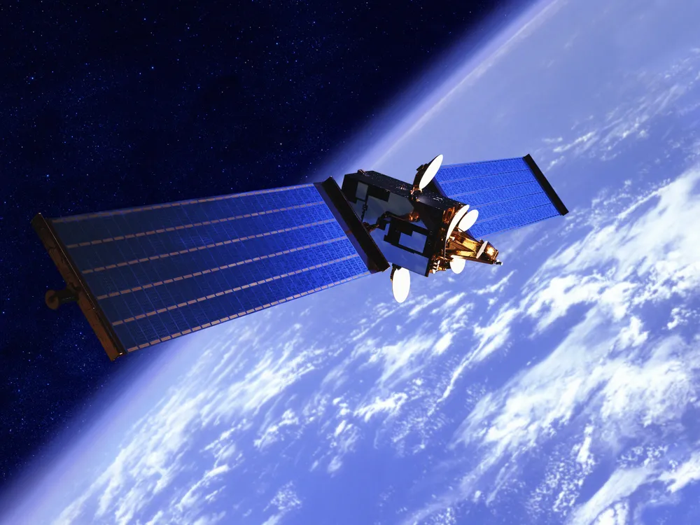 a satellite with solar panels above Earth