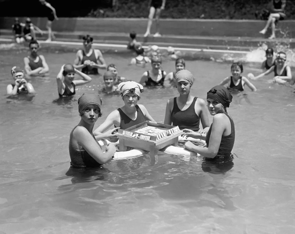 women play mahjong on floating table in a pool in 1924