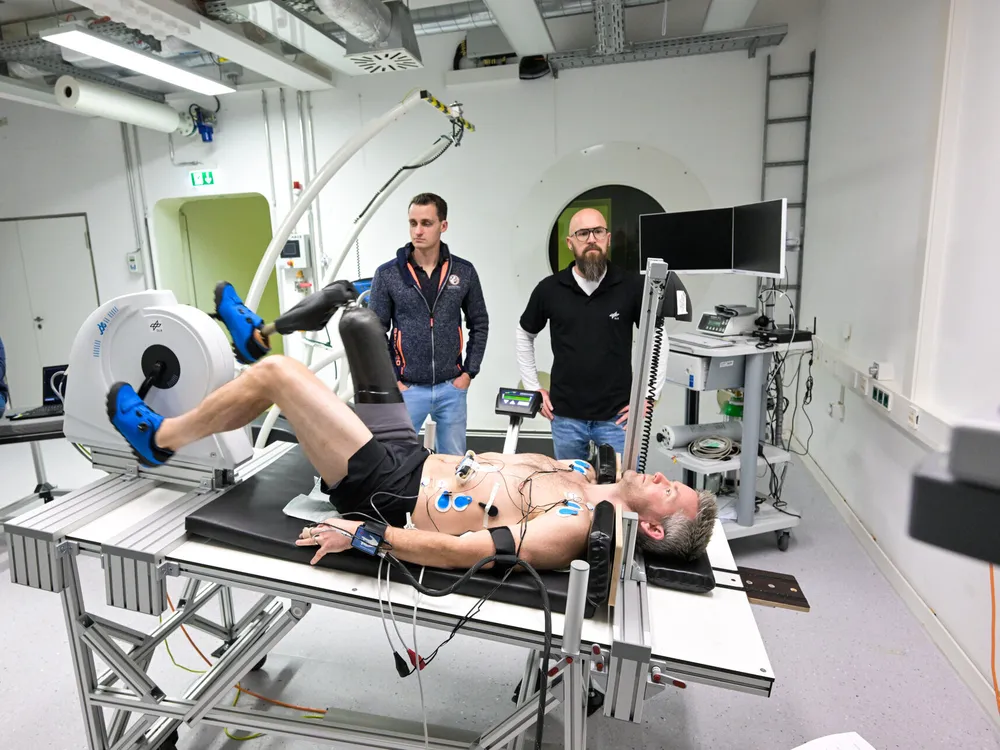 man with prosthetic leg lies on a table pedaling a horizontal bike device